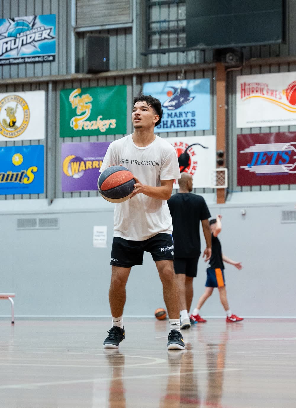 Coach with a ball on court before a small group session